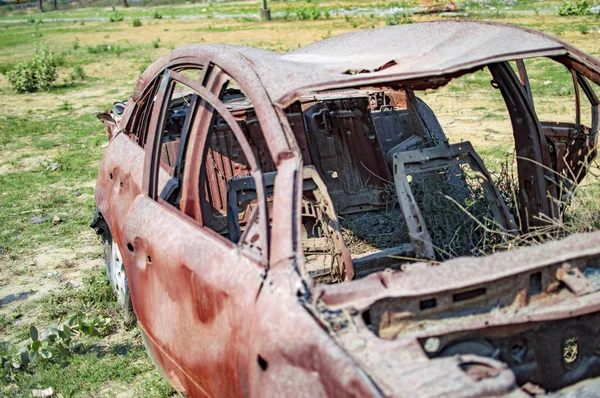 燃えた側面の眺めと地面に草を持つ燃えた車 — ストック写真