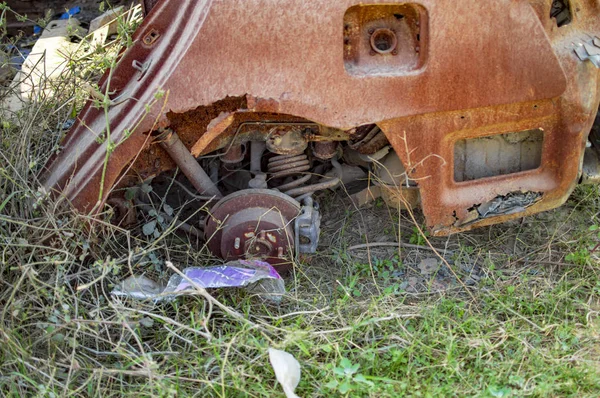 Spálené auto na zemi s trávou a jinými malými rostlinami — Stock fotografie