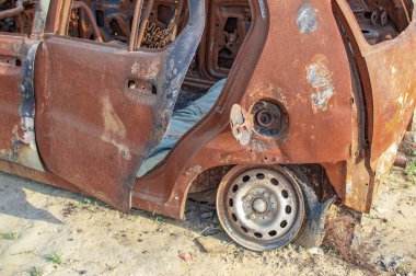 Yanlarında yanmış demir bulunan yanmış araba