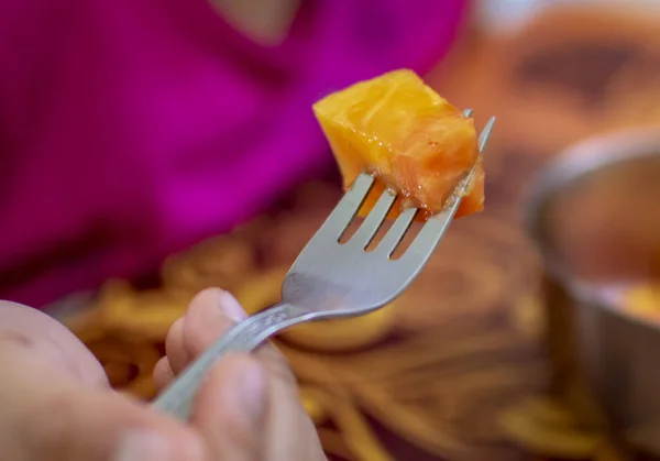 Eating papaya with fork of steel