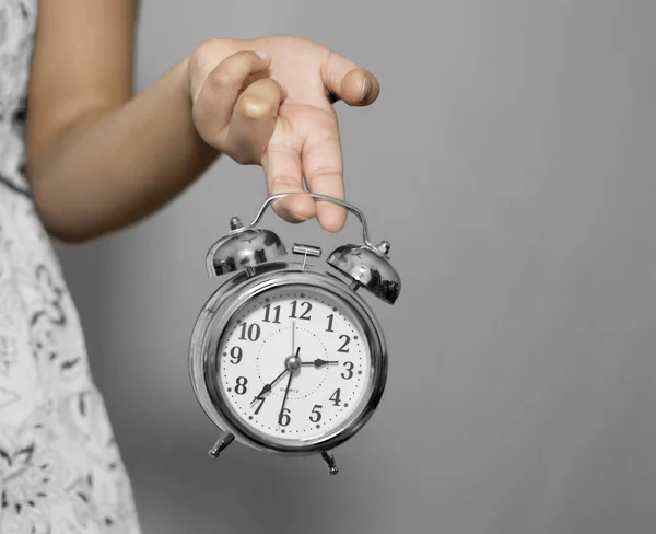 Uma menina segurando despertador com os dedos — Fotografia de Stock