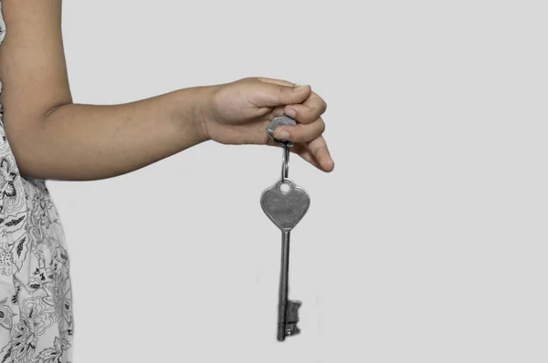 Una donna tiene la chiave in mano sul bianco — Foto Stock