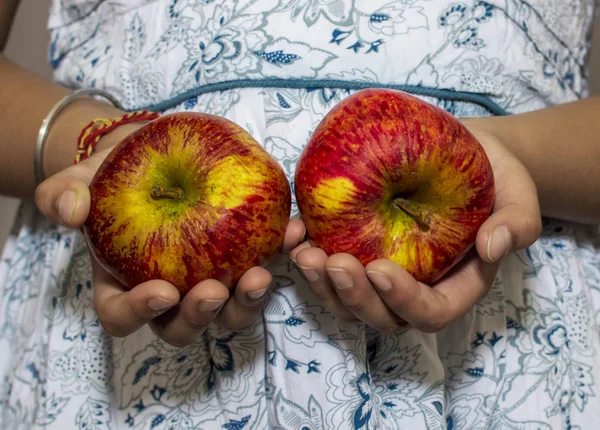 Два яблока в руках девушки в каждой руке, имеющей по одному — стоковое фото
