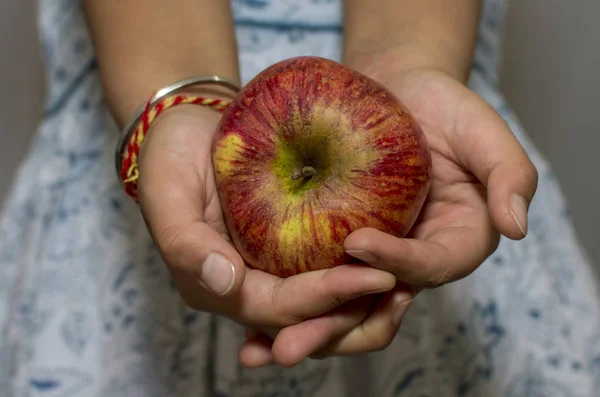 Elinde bir elma ve her iki sinde de tutuluyor — Stok fotoğraf