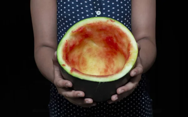 Leere Wassermelone in Händen und mit Fingern halten Stockbild