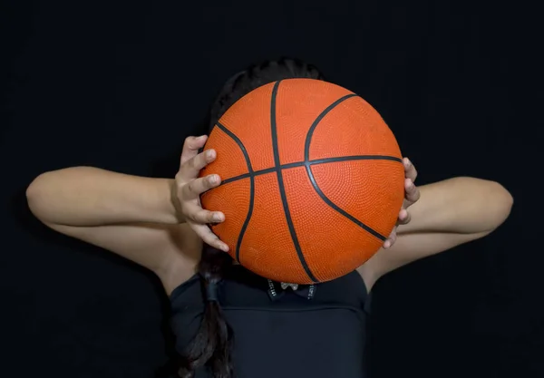 Woman holding a red basketball in the hands — ストック写真