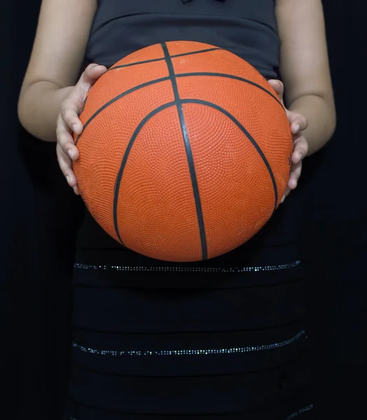 Молодая женщина держит баскетбол в руках — стоковое фото