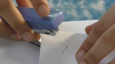 Bir kadın kağıtları zımbayla zımbayla zımbalıyor..