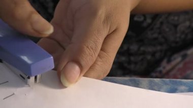 Bir kadın kağıtları zımbayla zımbayla zımbayla zımbalıyor..