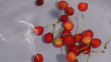 Yeşil saplı ve köpüklü beyaz suda süzülen kirazlar.