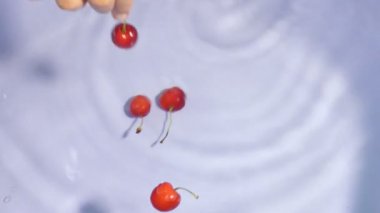 Suda yüzen kırmızı renkli kirazlar çubuklarla