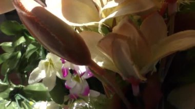 Teras bahçesinde rengarenk suni çiçekler var.