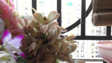 Teras bahçesinde duvarları ve çitleri olan renkli yapay çiçekler..