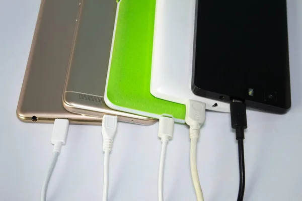 Beyaz arka plan üzerinde akıllı telefonlar şarj