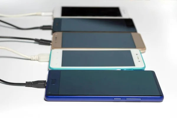 USB kabloları ile şarj akıllı telefonlar, bulanık, beyaz arka planda izole