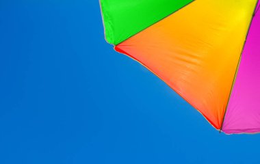 Açık mavi arkaplanda çok renkli şemsiye