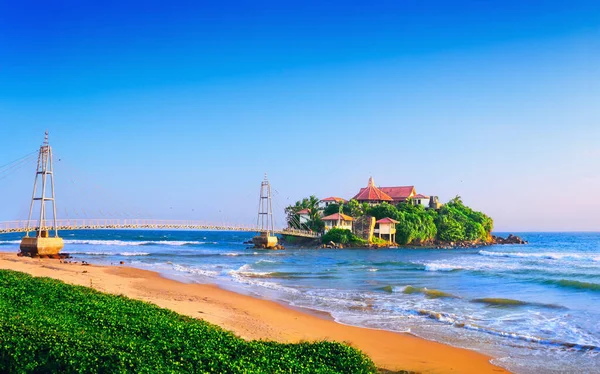 Manzarası çok güzel. Budist Parey Duwa tapınağı olan küçük bir ada ve Matara, Sri Lanka, Güney Asya yakınlarındaki Hint Okyanusu 'nun parlak mavi gökyüzünün arka planında bir köprü.