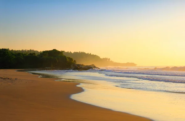 美しい景色 タンガラビーチ スリランカ島 インド洋 南アジアでの日の出前のカラフルな朝の空を背景にした海の波 湿った砂 岩や木 — ストック写真