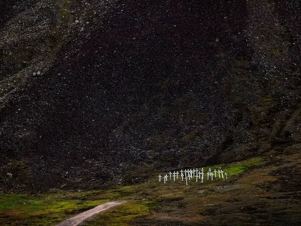 Şiddetli kutup manzarası - Longyear, Spitsbergen (Svalbard Adası), Norveç 'teki çorak siyah dağın arka planında birkaç beyaz haçı olan eski bir mezarlık