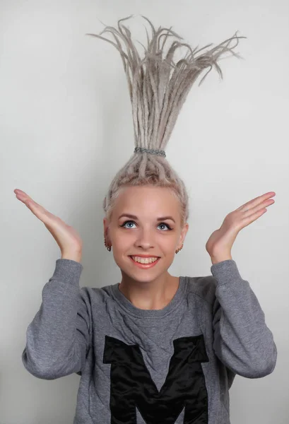 dreadlocks ve gri arka plan üzerinde mavi gözlü genç güzel pozitif beyaz kız