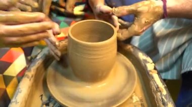 Potter'ın ona çanak çömlek çarkı ile çalışmaya yardımcı olmak için yol gösterici çocuğun el eller. Potter's tekerlek kil heykel küçük bir çocuk öğrenir