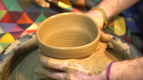 陶工の手の陶器のホイールで動作するように彼を助けるために子供の手を導きます 小さな子供陶芸のろくろに粘土を彫ることを学ぶ — ストック動画