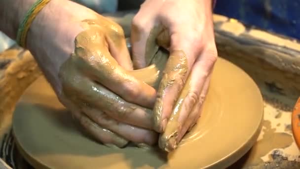Potter je rukou vedení dítěte ruce k pomoci mu, aby práce s hrnčířského kruhu. Malé dítě se učí vyřezávat hlíny na hrnčířský kruh