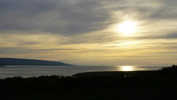 Puslu bir akşam Barents Denizi'nin bir koy.