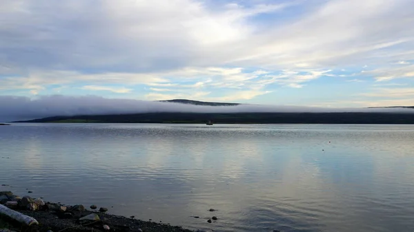 Puslu bir akşam Barents Denizi'nin bir koy.