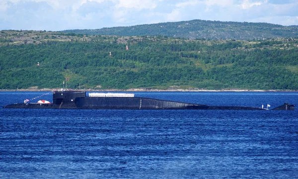 Delta-IV sınıfının bir Rus nükleer enerjili balistik füze denizaltısı Kola Bay, Rusya'da şamandıra için güneşli bir kutup günde demirleyen.