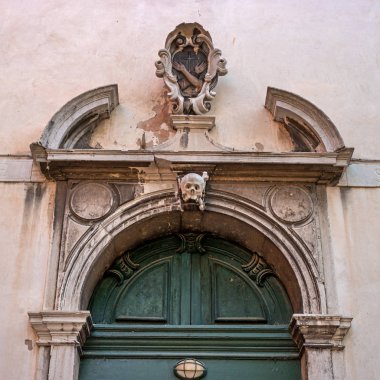 Eski kilise kapı Venedik. Parçası. İtalya. Kapıyı bas-reliefs ve dekoratif öğeler ile dekore edilmiştir. Kapıyı bir kafatası heykel..