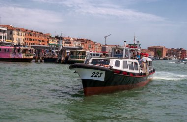 Venice, İtalya - 07 Mayıs 2018: Vaporetto deniz otobüsü ile turistler boyunca yüzüyor. İskele üzerinde vaporetto durağı ve gondol moorings vardır. Yolcu fotoğraflandı vaporetto konumlar.