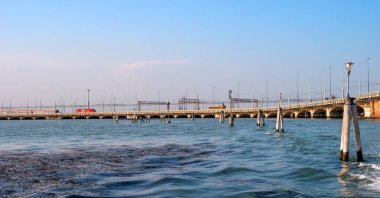 Ponte della Libertà - anlamı Özgürlük Köprüsü - Venice Mestre oteli anakara için bağlama. Köprüde trene biniyor. Köprü otobüs sürmek. Ön planda, fairway sütunlar.