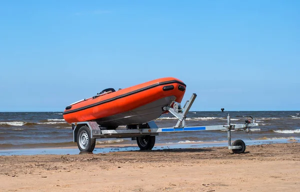 Cankurtaran römork üzerinde. Cankurtaran turuncu olduğunu. Römork tekne ile su kıyısında olduğunu. Sandy beach
