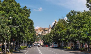 Bergamo, İtalya - 10 Mayıs 2018: Street ve arka plan üzerinde çan kulesi önünde ve Citta Alta ile şehir merkezinde trafik. İnsanlar sokakta