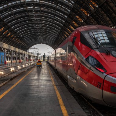 Venice, İtalya - 08 Mayıs 2018: yüksek hızlı tren Trenitalia Milan tren istasyonunda. Bir işçi bir elektrikli araç üzerinde platform gidiyor. Platform bir ajur metal kemer vardır