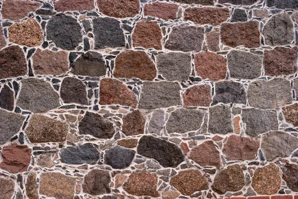 Pared de piedras. Piedras de diferentes formas y colores. El mortero que conecta la mampostería es blanco. Muy adecuado como fondo o textura —  Fotos de Stock