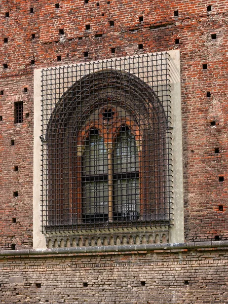 Sforza Castle in Milan, northern Italy. Window on the fortress wall. On the window is a steel lattice Royalty Free Stock Images