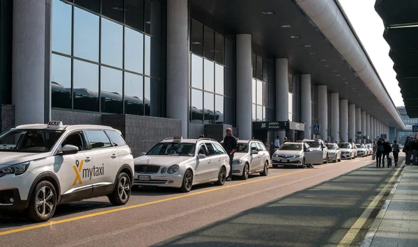 Malpensa airport, İtalya - 18 Ekim 2018: Malpensa Havalimanı'nda taksi. Yolcular için bekleyen taksi. Beyaz taksi Havaalanı Otopark.