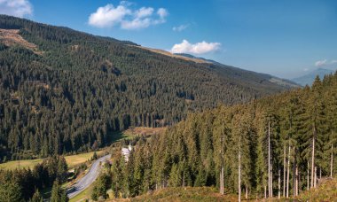 Sonbahar Orman dağlarda. Avusturya. Yüksek Ladin ve nazik etekleri Alplerinin ortasından geçiyordu. Kalın çim ağaçları dibinde. Göl Weissensee değil çok uzakta. Yolun ve kilisenin altında.