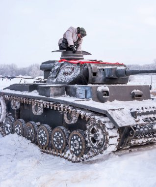 Krasnoye Selo, St. Petersburg, Rusya Federasyonu - 19 Ocak 2019: Askeri tarihi yeniden yapılanma - Leningrad için savaş. Tank Pzkpfw III savaş için hazırlanıyor. Tankman tank içine tırmanıyor.