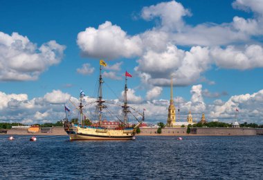 Marine parade in St. Petersburg. Sailing Russian frigate Poltava on the Neva in the center of St. Petersburg. Panaroma of the Peter and Paul Fortress. clipart