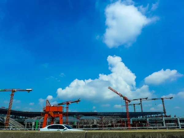 karayolu üzerinde mavi gökyüzü ile bulutlar arka plan bakmak inşaat alanında Vinçler