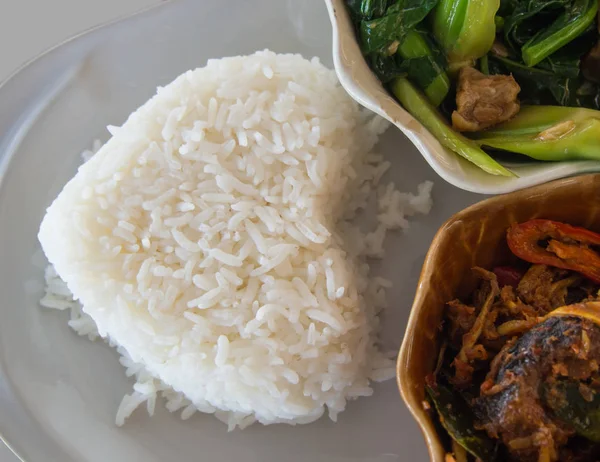 Kızarmış balık ilave edin ve karıştırın kızarmış sebze beyaz tabakta kasede pirinç