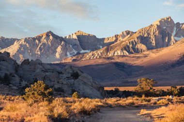 Early morning sunrise in fall hits the mountains of the eastern Sierra Nevada near Bishop, California clipart