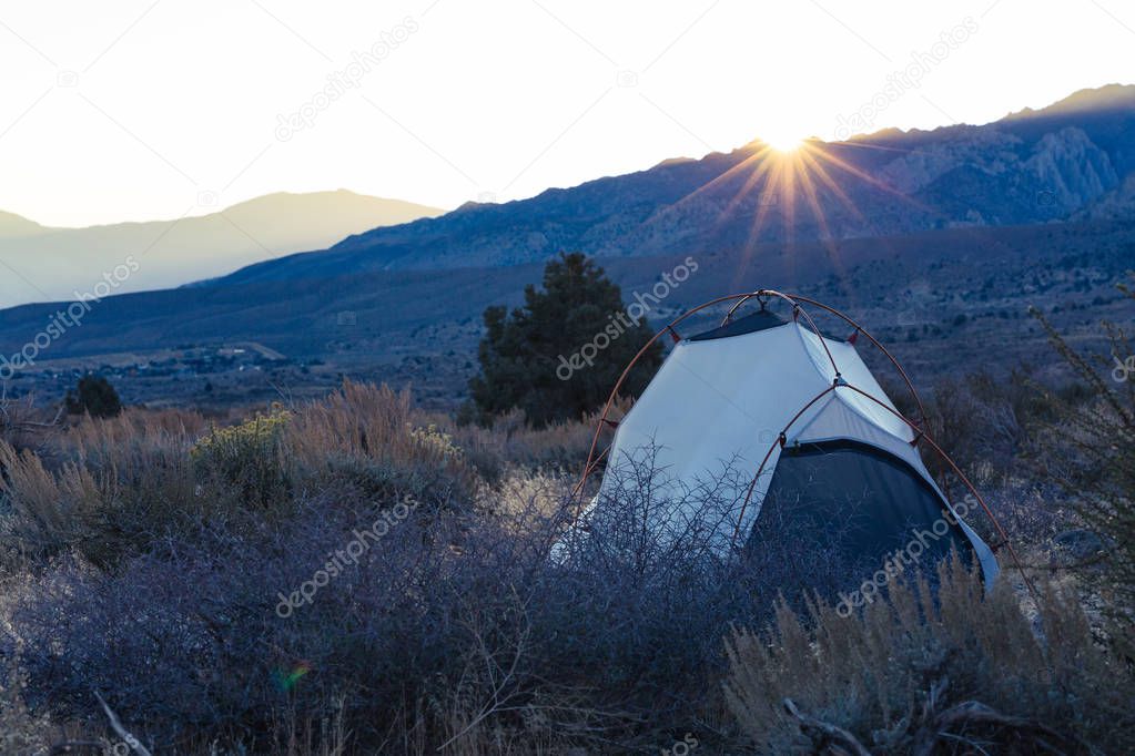 Sunrise on a tent pitched in the high desert of Bishop, California surrounded by the mountains of the Sierra Nevada
