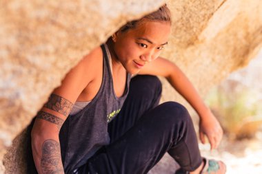 Petite Asyalı kadın kaya tırmanışı, Closeup açık havada sorunu üzerinde yoğunlaşmaktadır