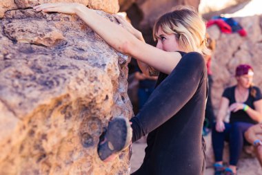 İnce sarışın beyaz kadın kolu mücadeleler kayalar California Çölü üzerinde dağcılık yaparken dövmeler