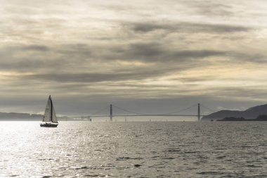 Bir teknede su Marnixkade San Francisco Körfezi üzerinden bir bulutlu gün batımı. Şehrin manzaralarını ve golden gate köprüsü
