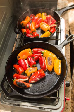 Dökme demir tavada kamp gezisi sırasında hazırlanan peynir dolgulu kurutulmuş biber